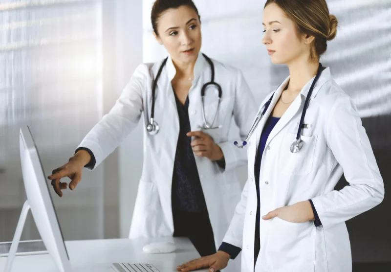 Two healthcare professionals reviewing information together on a computer
